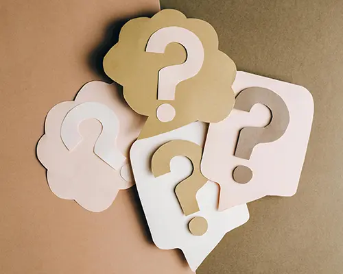 Cut-out speech bubbles and question marks in neutral tones on a brown background.